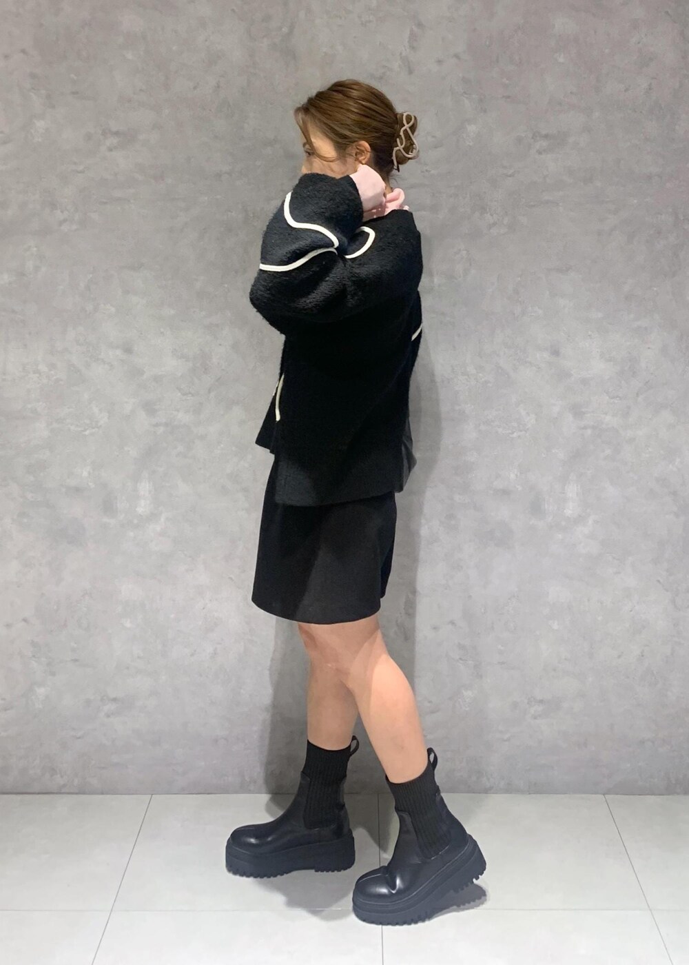 ブラック系のショルダーバッグ、ブラック系のブーツ、ブラック系のニット/セーターを着用したレディースの冬コーディネートの4枚目の写真