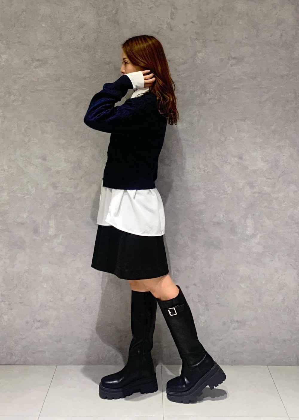 ブラック系のブーツ、ブラック系のスカート、ブルー系のその他アウターを着用したレディースの秋コーディネートの7枚目の写真