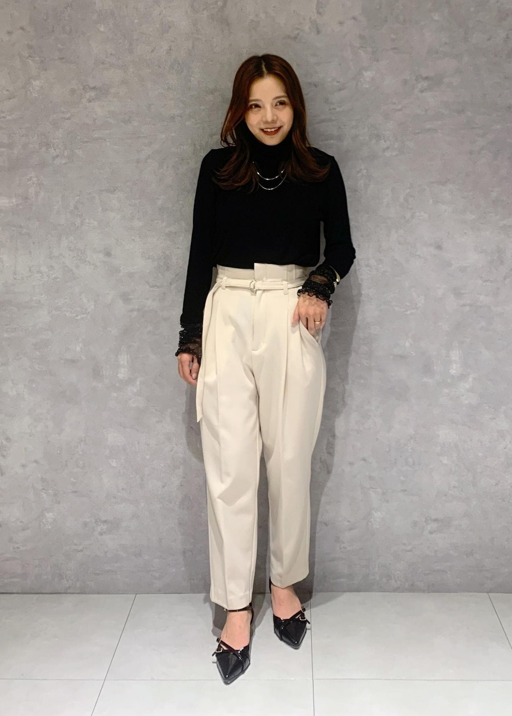 ブラック系のパンプス、グレー系のポンチョ、ブラック系のTシャツ/カットソーを着用したレディースの秋コーディネートの7枚目の写真