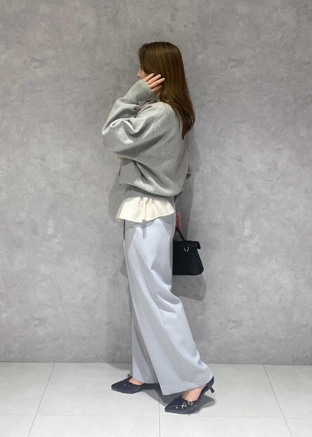 ブラック系のショルダーバッグ、ホワイト系のシャツ/ブラウス、ブルー系のスラックスを着用したレディースの冬コーディネートの4枚目の写真