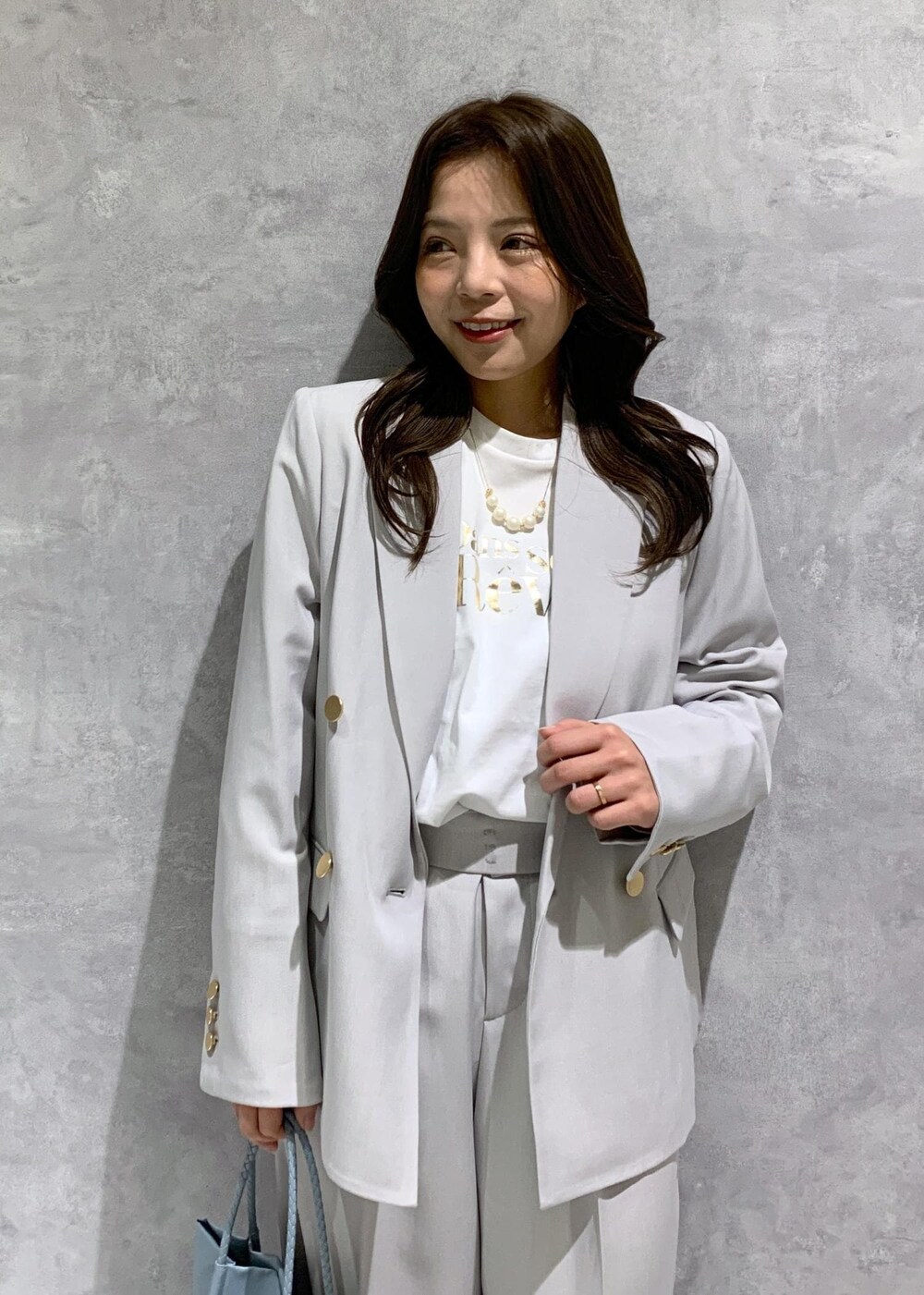 ブルー系のトートバッグ、ホワイト系のTシャツ/カットソー、ホワイト系のローファーを着用したレディースの冬コーディネートの6枚目の写真