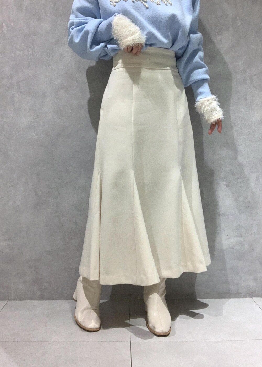 ホワイト系のニット/セーター、ホワイト系のブーツ、ホワイト系のハンドバッグを着用したレディースの冬コーディネートの10枚目の写真