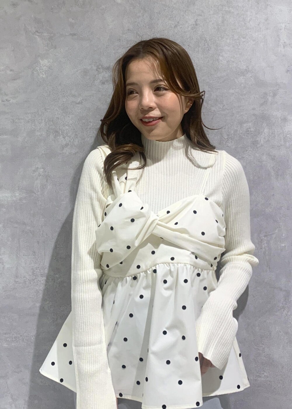 ブラック系のショルダーバッグ、ホワイト系のニット/セーター、ブラック系のスカートを着用したレディースの冬コーディネートの8枚目の写真