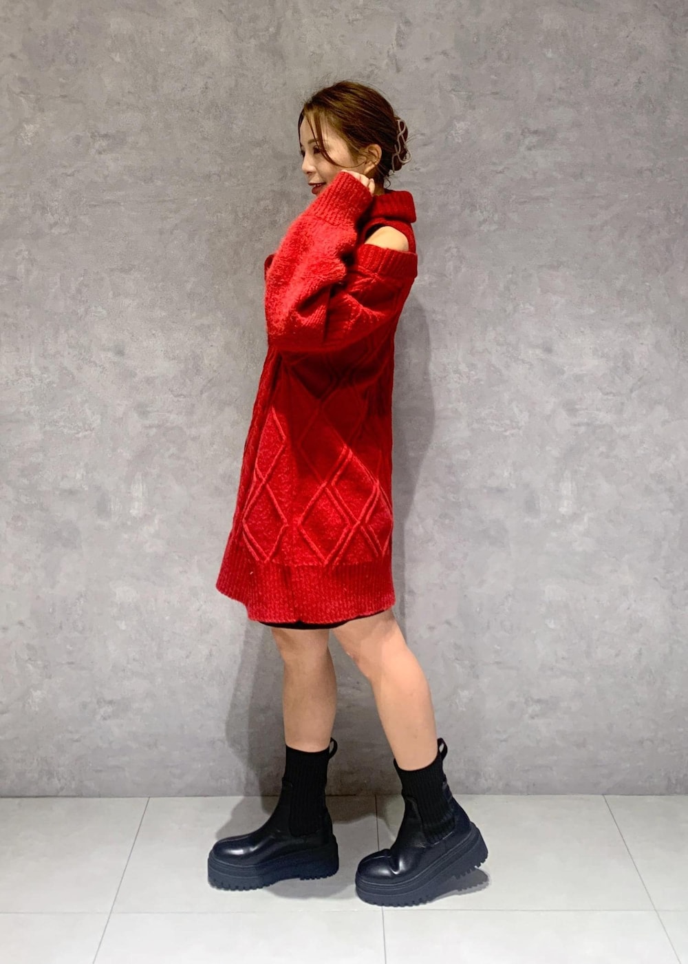 ブラック系のショルダーバッグ、ブラック系のブーツ、レッド系のワンピースを着用したレディースの冬コーディネートの8枚目の写真