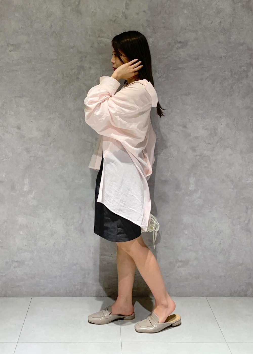 ピンク系のシャツ/ブラウス、グレー系のローファー、ホワイト系のハンドバッグを着用したレディースの春コーディネートの4枚目の写真