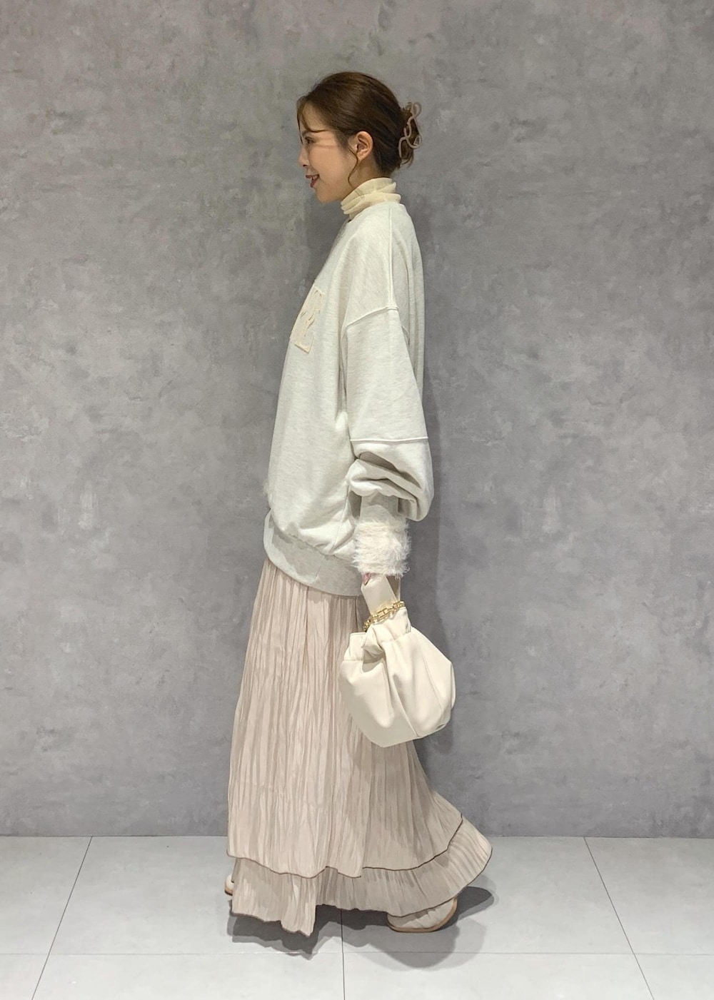 ホワイト系のブーツ、ベージュ系のスカート、ホワイト系のニット/セーターを着用したレディースの秋コーディネートの4枚目の写真