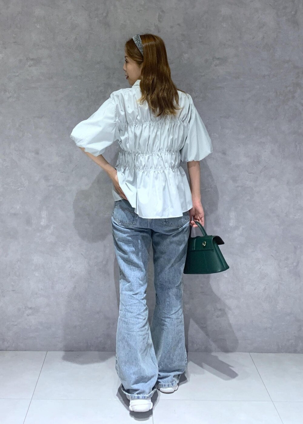 グリーン系のショルダーバッグ、ブルー系のデニムパンツ、グリーン系のシャツ/ブラウスを着用したレディースの夏コーディネートの5枚目の写真