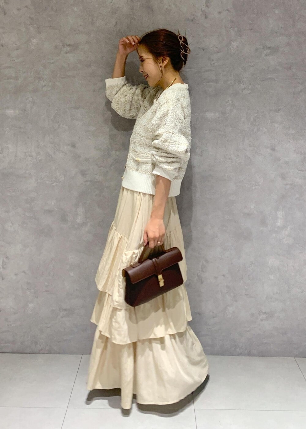 ブラウン系のショルダーバッグ、ブラウン系のブーツ、ホワイト系のカーディガン/ボレロを着用したレディースの夏コーディネートの3枚目の写真