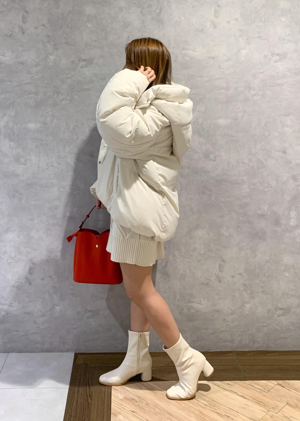 ホワイト系のブーツ、ホワイト系のワンピース、ホワイト系のダウンジャケット/コートを着用したレディースの秋コーディネートの3枚目の写真