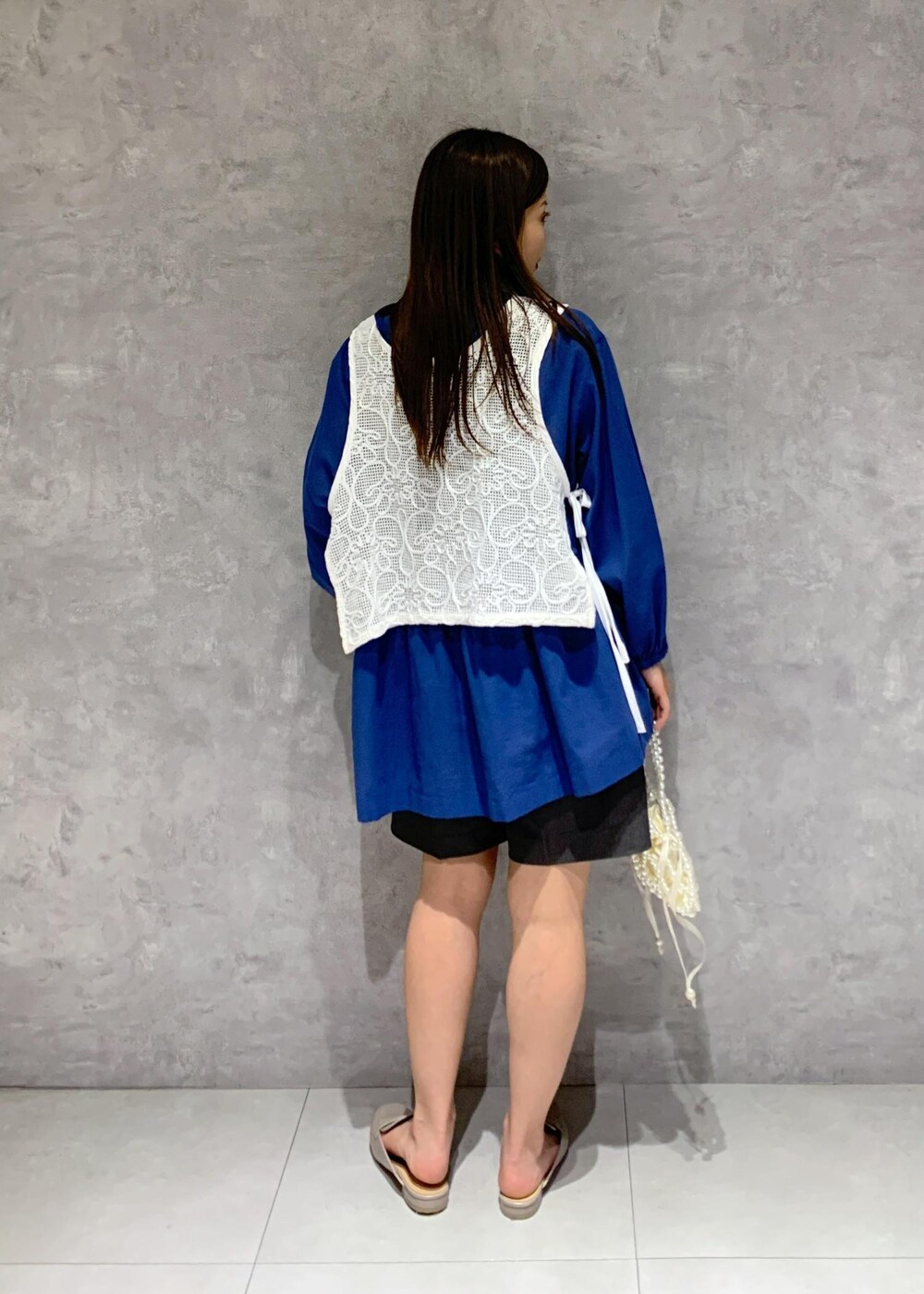 ブルー系のシャツ/ブラウス、グレー系のローファー、ホワイト系のハンドバッグを着用したレディースの春コーディネートの5枚目の写真