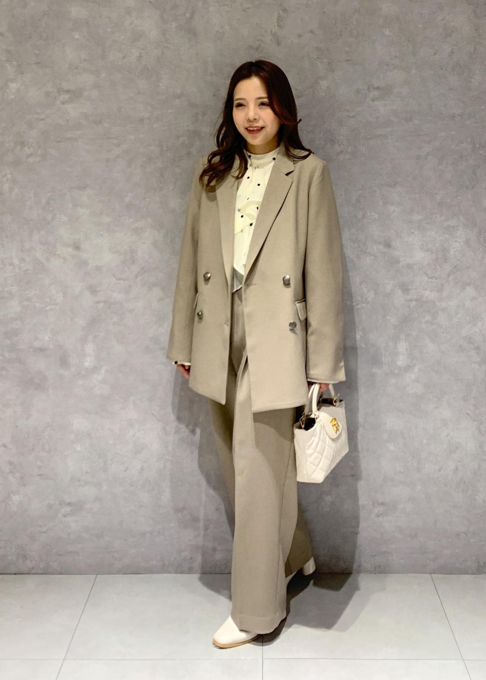 ホワイト系のブーツ、ベージュ系のシャツ/ブラウス、ベージュ系のスラックスを着用したレディースの冬コーディネートの3枚目の写真