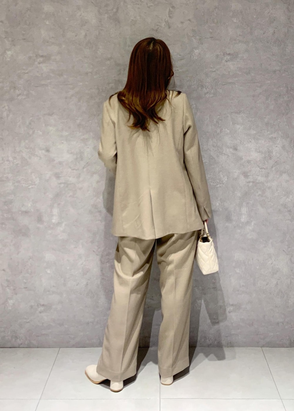 ホワイト系のブーツ、ベージュ系のシャツ/ブラウス、ベージュ系のスラックスを着用したレディースの冬コーディネートの5枚目の写真