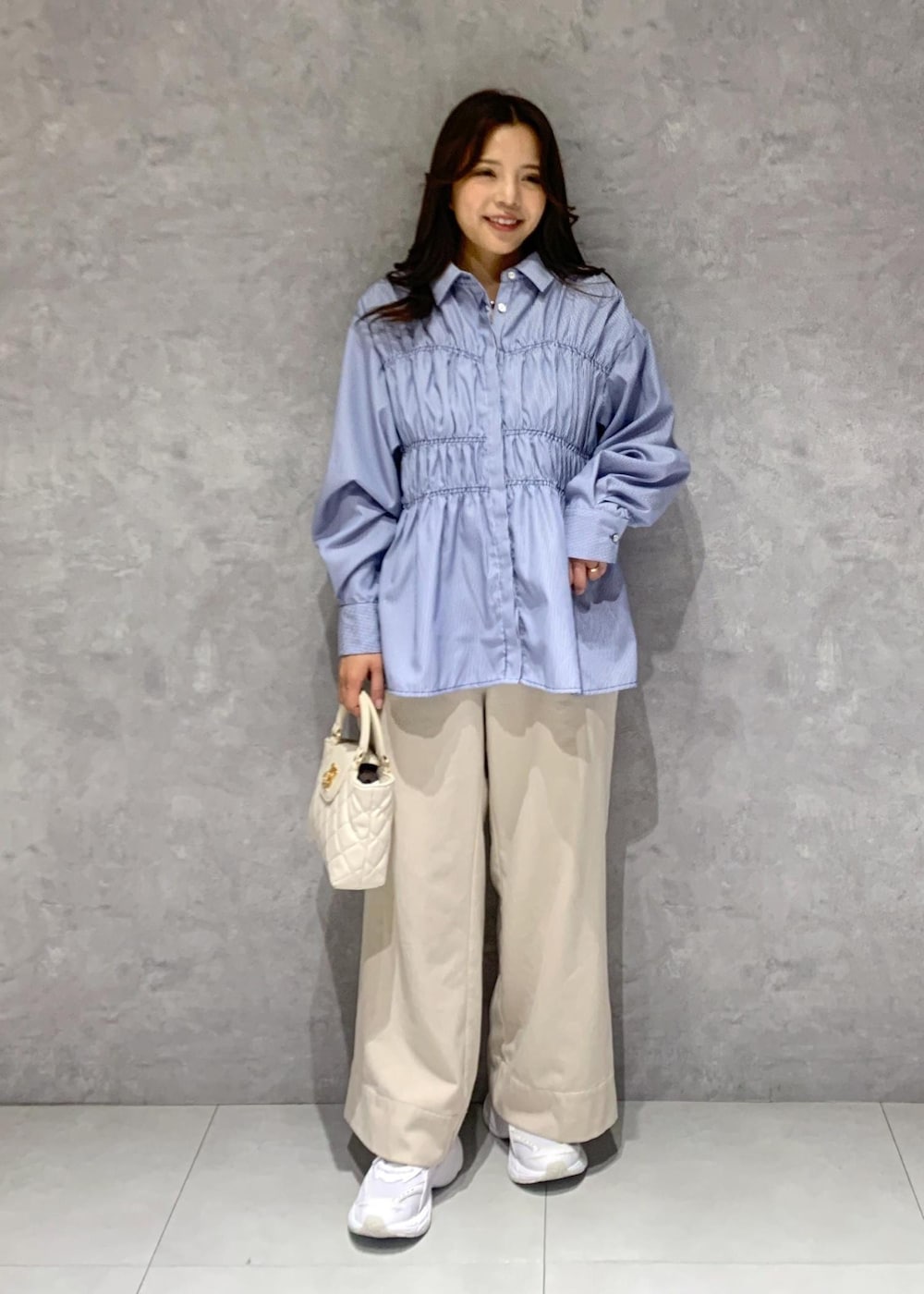 ブルー系のシャツ/ブラウス、ベージュ系のその他パンツ、ホワイト系のショルダーバッグを着用したレディースの冬コーディネートの7枚目の写真