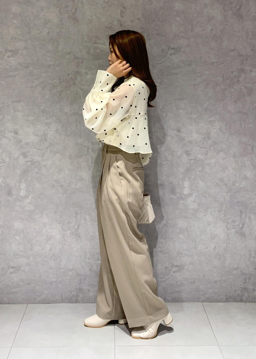 ホワイト系のブーツ、ベージュ系のシャツ/ブラウス、ベージュ系のスラックスを着用したレディースの冬コーディネートの7枚目の写真