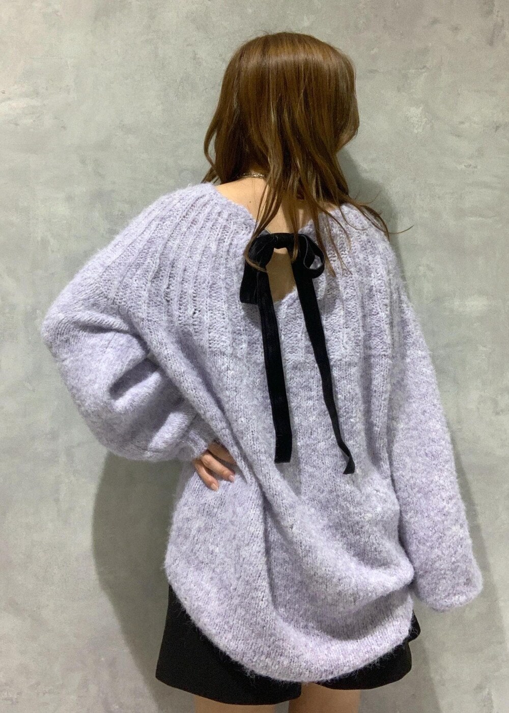 ブラック系のブーツ、パープル系のニット/セーター、ブラック系のその他パンツを着用したレディースの冬コーディネートの9枚目の写真