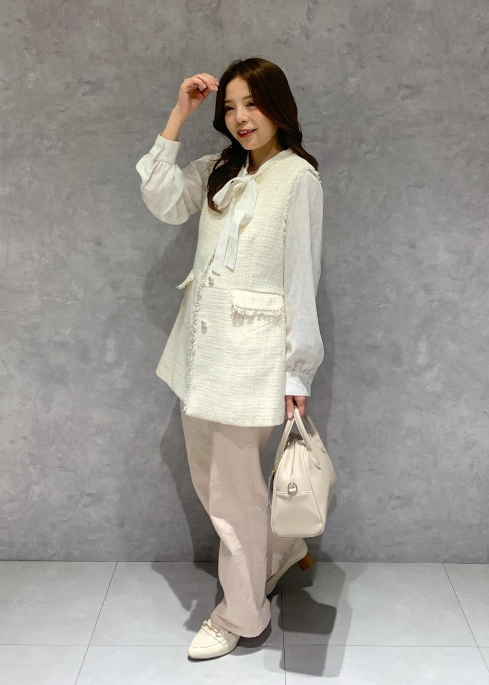 ピンク系のデニムパンツ、ホワイト系のシャツ/ブラウス、ホワイト系のベストを着用したレディースの冬コーディネートの3枚目の写真