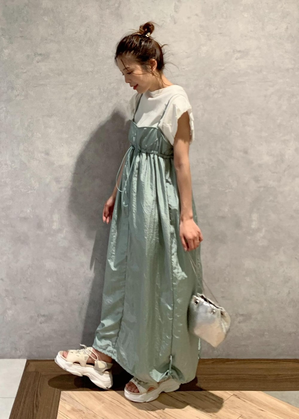 ベージュ系のサンダル、グリーン系のワンピース、ホワイト系のTシャツ/カットソーを着用したレディースの夏コーディネートの3枚目の写真