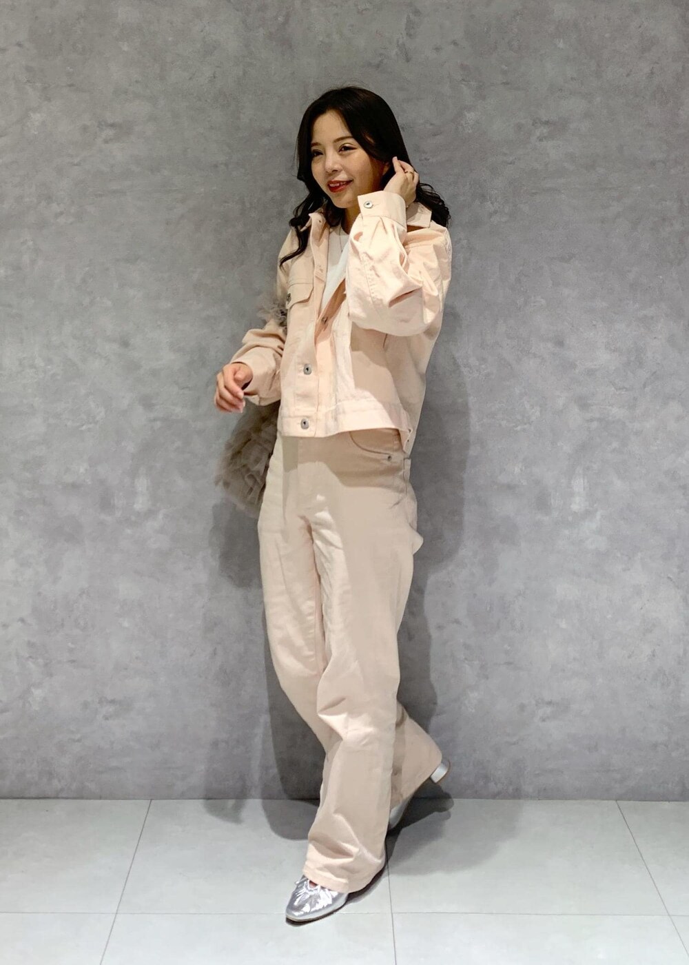 シルバー系のパンプス、ピンク系のデニムパンツ、ホワイト系のニット/セーターを着用したレディースの冬コーディネートの3枚目の写真