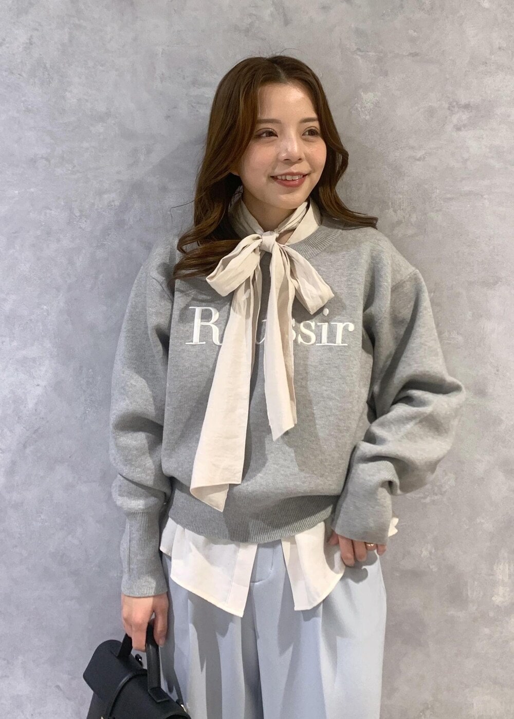 ブラック系のショルダーバッグ、ホワイト系のシャツ/ブラウス、ブルー系のスラックスを着用したレディースの冬コーディネートの7枚目の写真