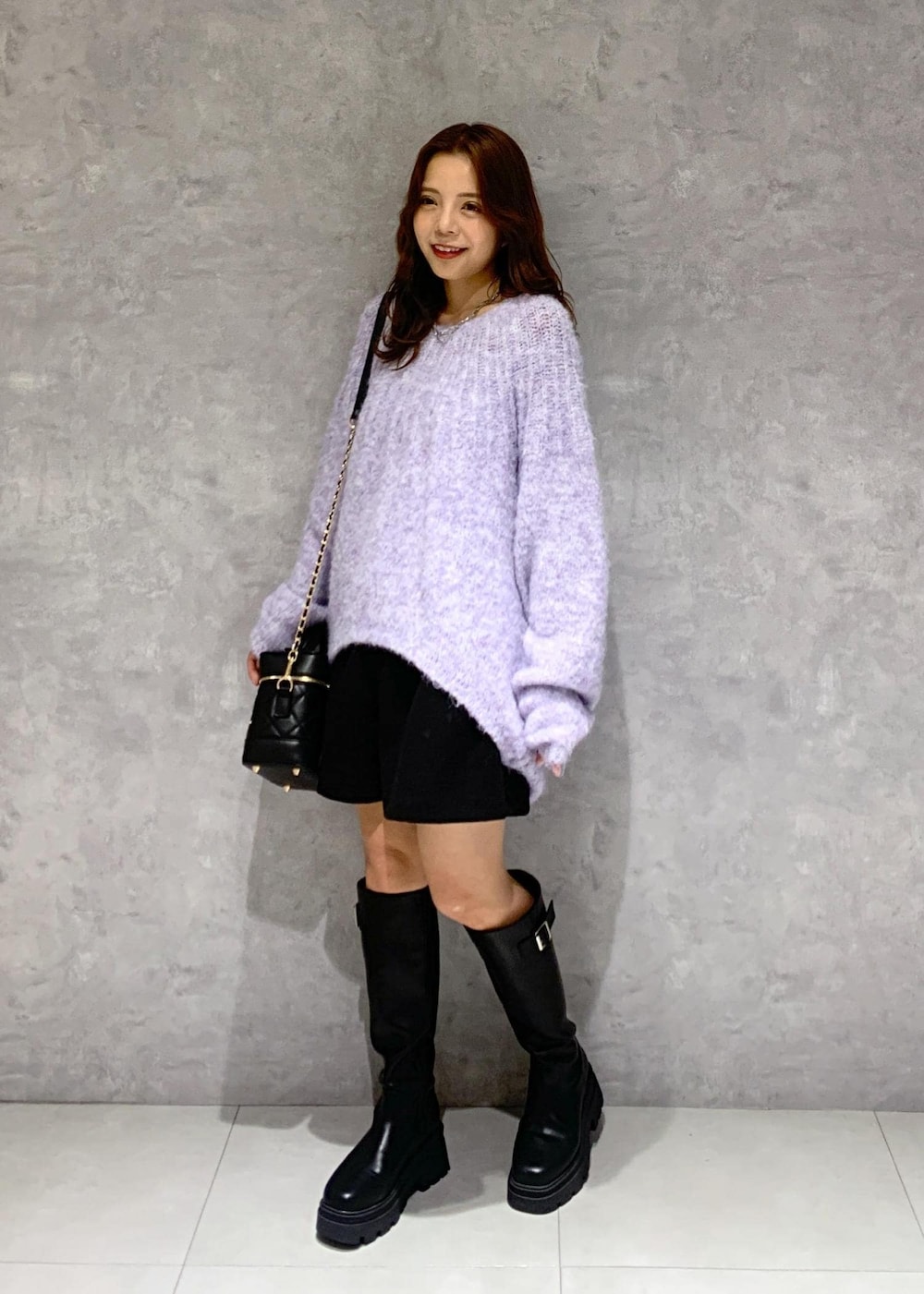 ブラック系のブーツ、パープル系のニット/セーター、ブラック系のその他パンツを着用したレディースの冬コーディネートの4枚目の写真