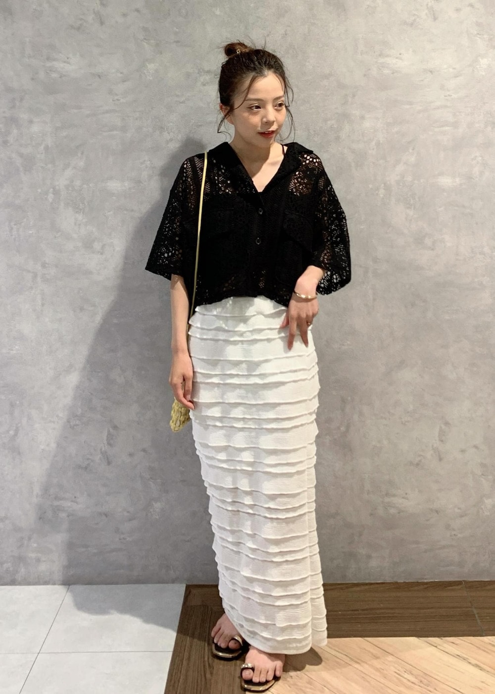 ブラック系のサンダル、ホワイト系のスカート、ブラック系のカーディガン/ボレロを着用したレディースの夏コーディネートの2枚目の写真