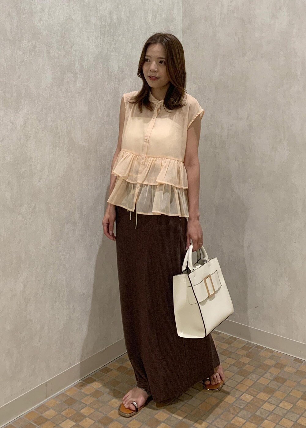 ベージュ系のサンダル、ホワイト系のハンドバッグ、ベージュ系のシャツ/ブラウスを着用したレディースの夏コーディネートの2枚目の写真