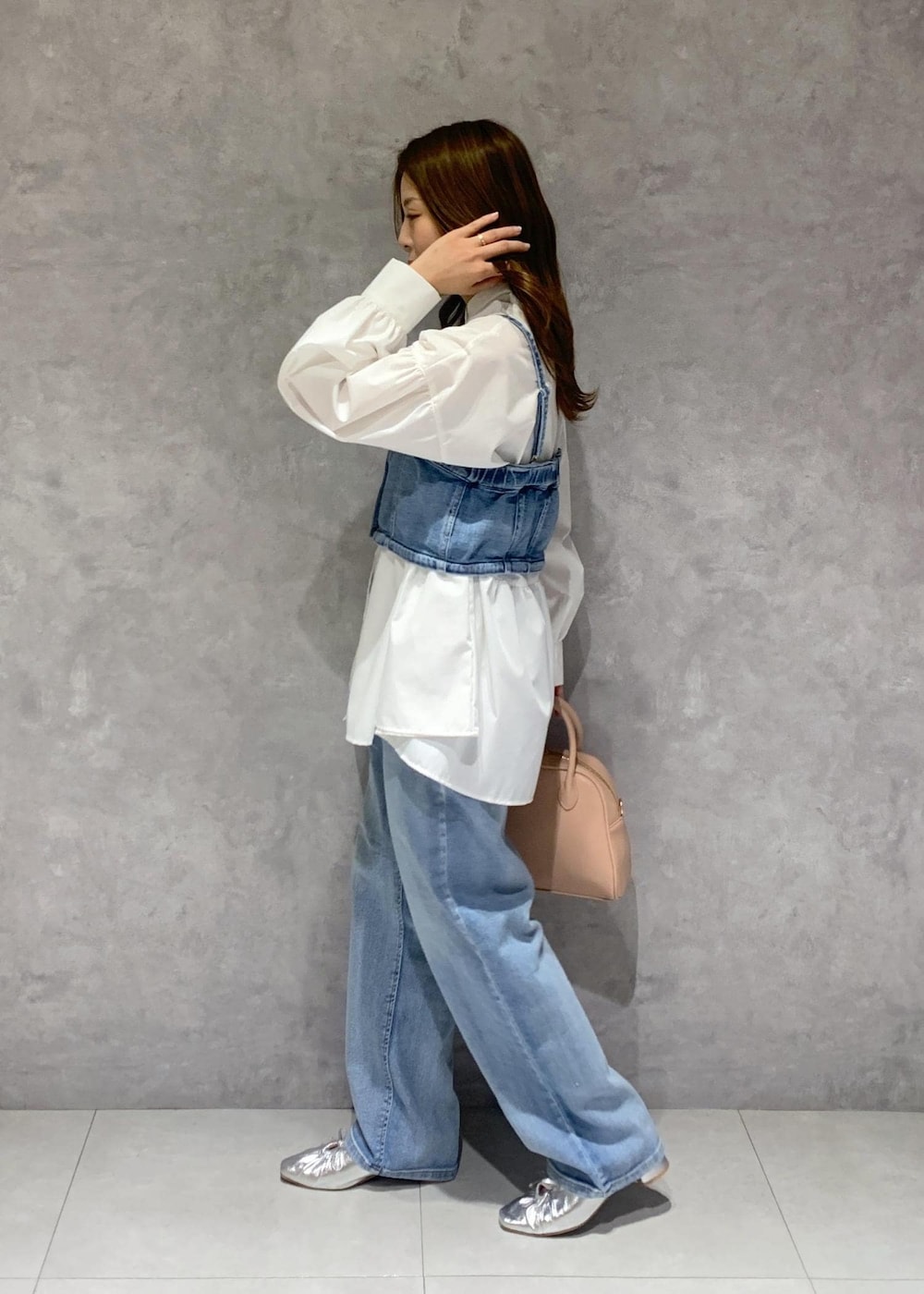 シルバー系のパンプス、ブルー系のベスト、ホワイト系のシャツ/ブラウスを着用したレディースの冬コーディネートの4枚目の写真