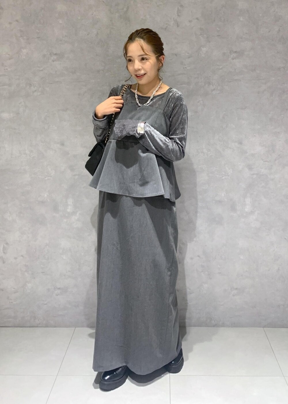 グレー系のワンピース、グレー系のTシャツ/カットソー、ブラック系のショルダーバッグを着用したレディースの秋コーディネートの2枚目の写真