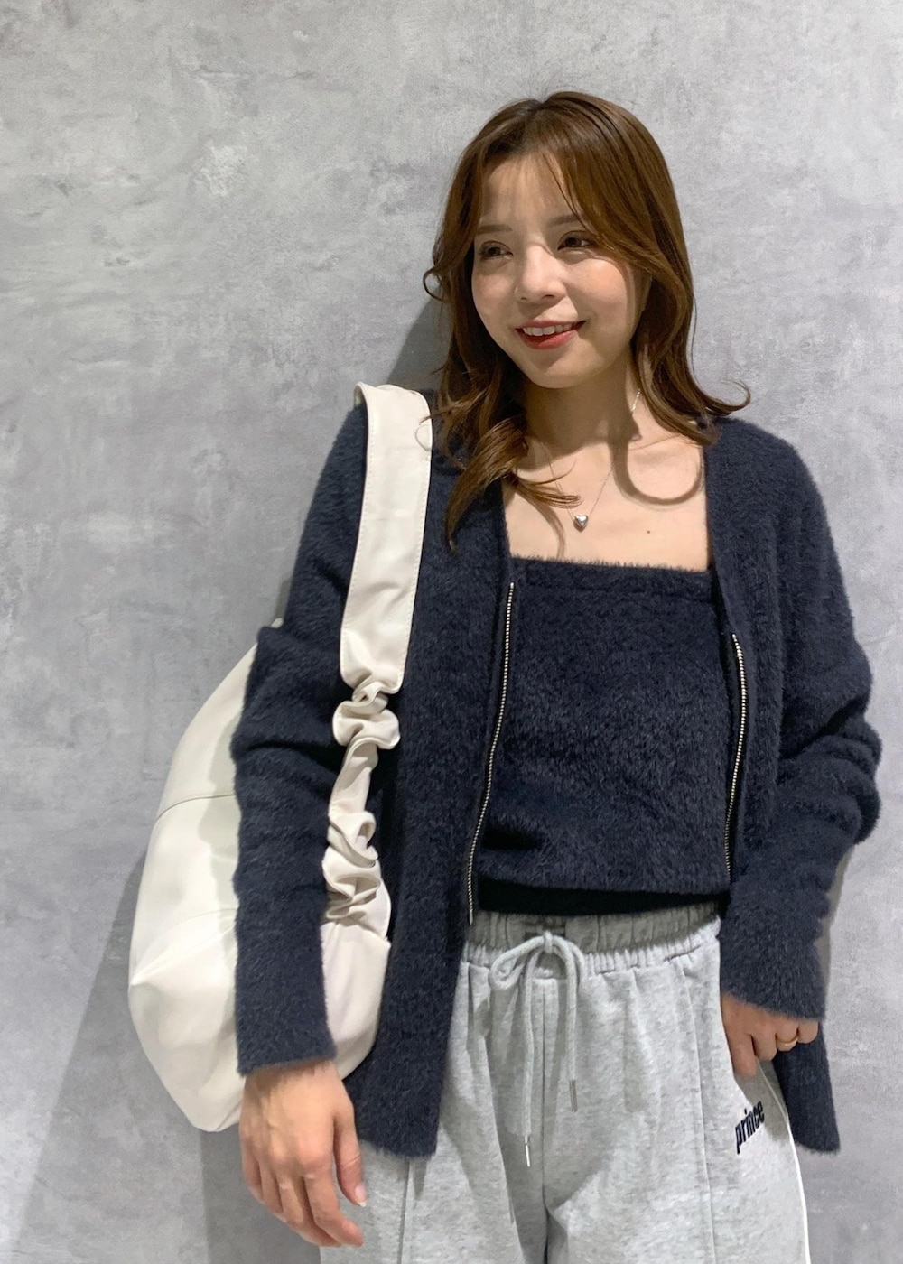 ブラック系のキャミソール、グレー系のその他パンツ、ホワイト系のショルダーバッグを着用したレディースの冬コーディネートの6枚目の写真