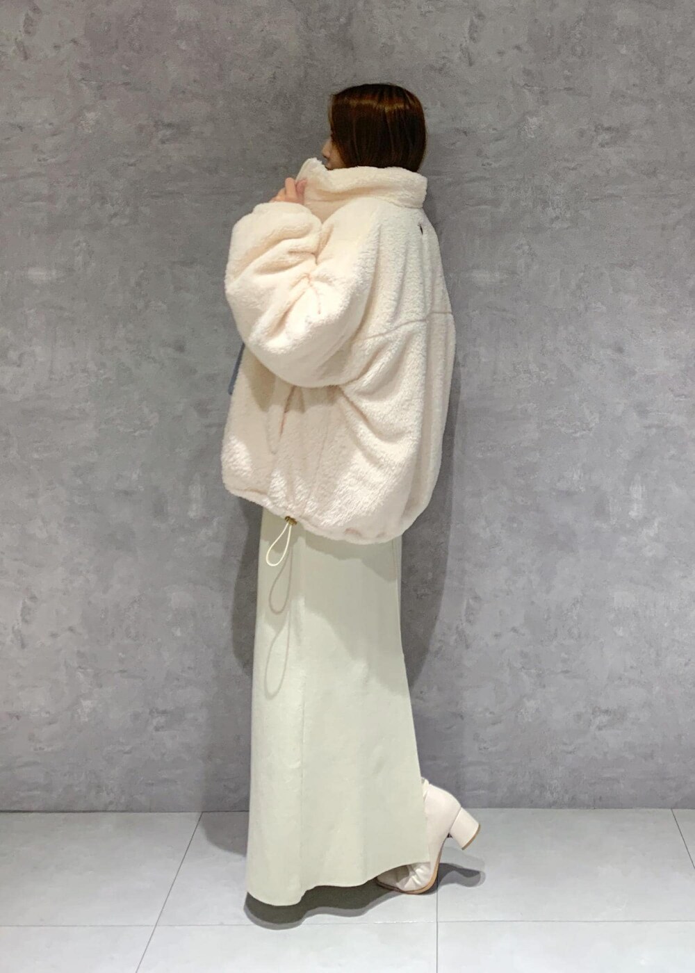 ホワイト系のブーツ、ホワイト系のスカート、ホワイト系のブルゾンを着用したレディースの秋コーディネートの4枚目の写真