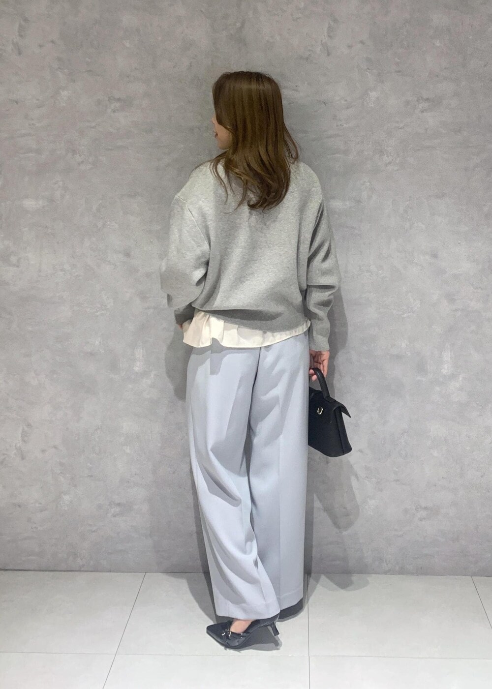 ブラック系のショルダーバッグ、ホワイト系のシャツ/ブラウス、ブルー系のスラックスを着用したレディースの冬コーディネートの5枚目の写真