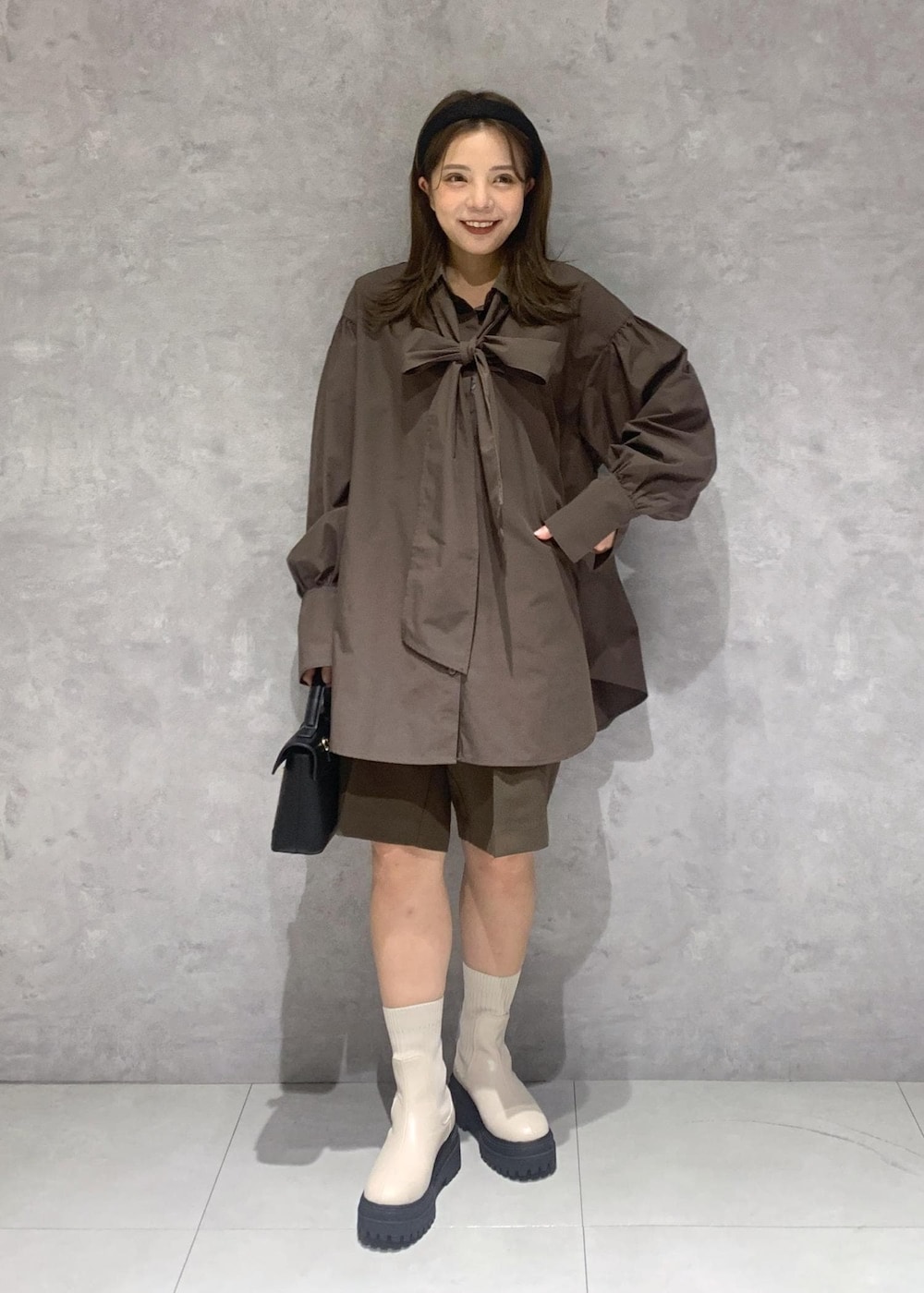 ホワイト系のブーツ、ブラウン系のその他パンツ、ホワイト系のハンドバッグを着用したレディースの秋コーディネートの8枚目の写真