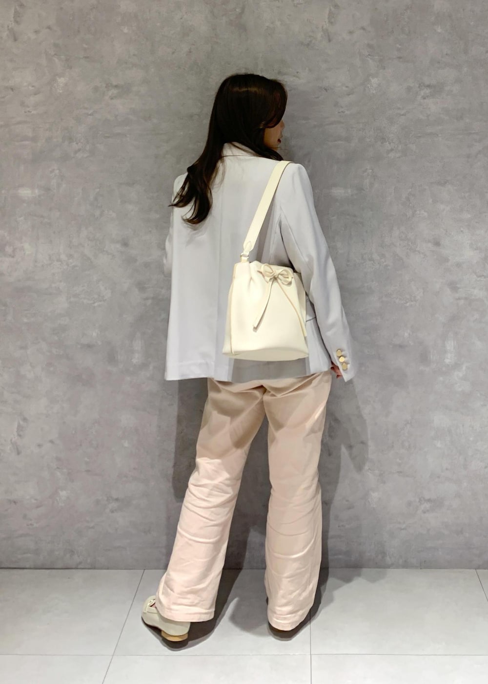 ホワイト系のハンドバッグ、ピンク系のデニムパンツ、ホワイト系のニット/セーターを着用したレディースの冬コーディネートの6枚目の写真