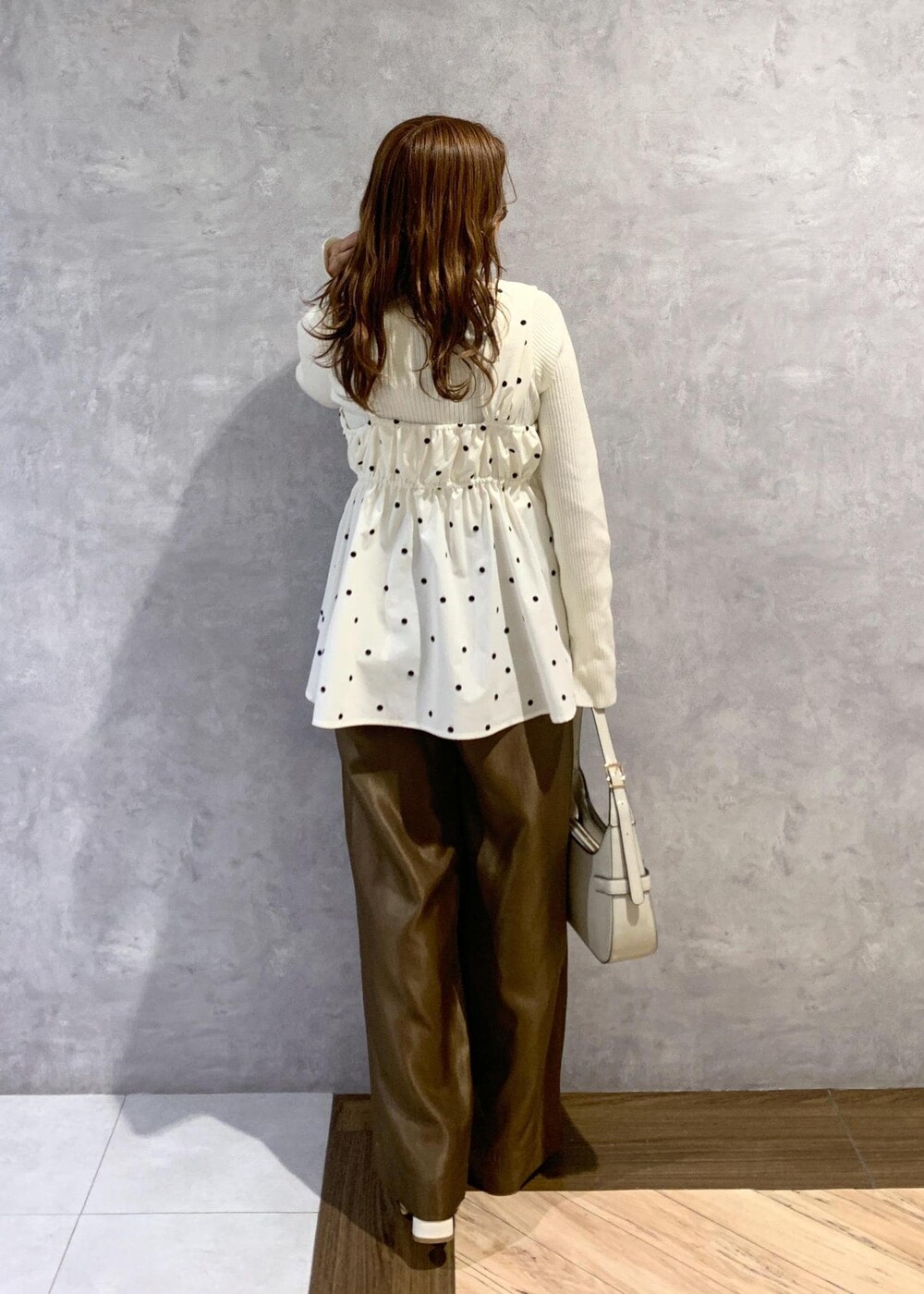 ホワイト系のブーツ、ホワイト系のニット/セーター、ホワイト系のハンドバッグを着用したレディースの冬コーディネートの4枚目の写真