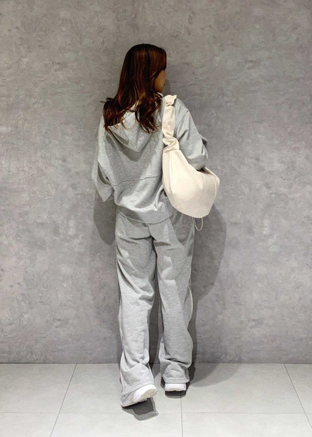 グレー系のその他パンツ、グレー系のパーカー、ホワイト系のショルダーバッグを着用したレディースの冬コーディネートの9枚目の写真