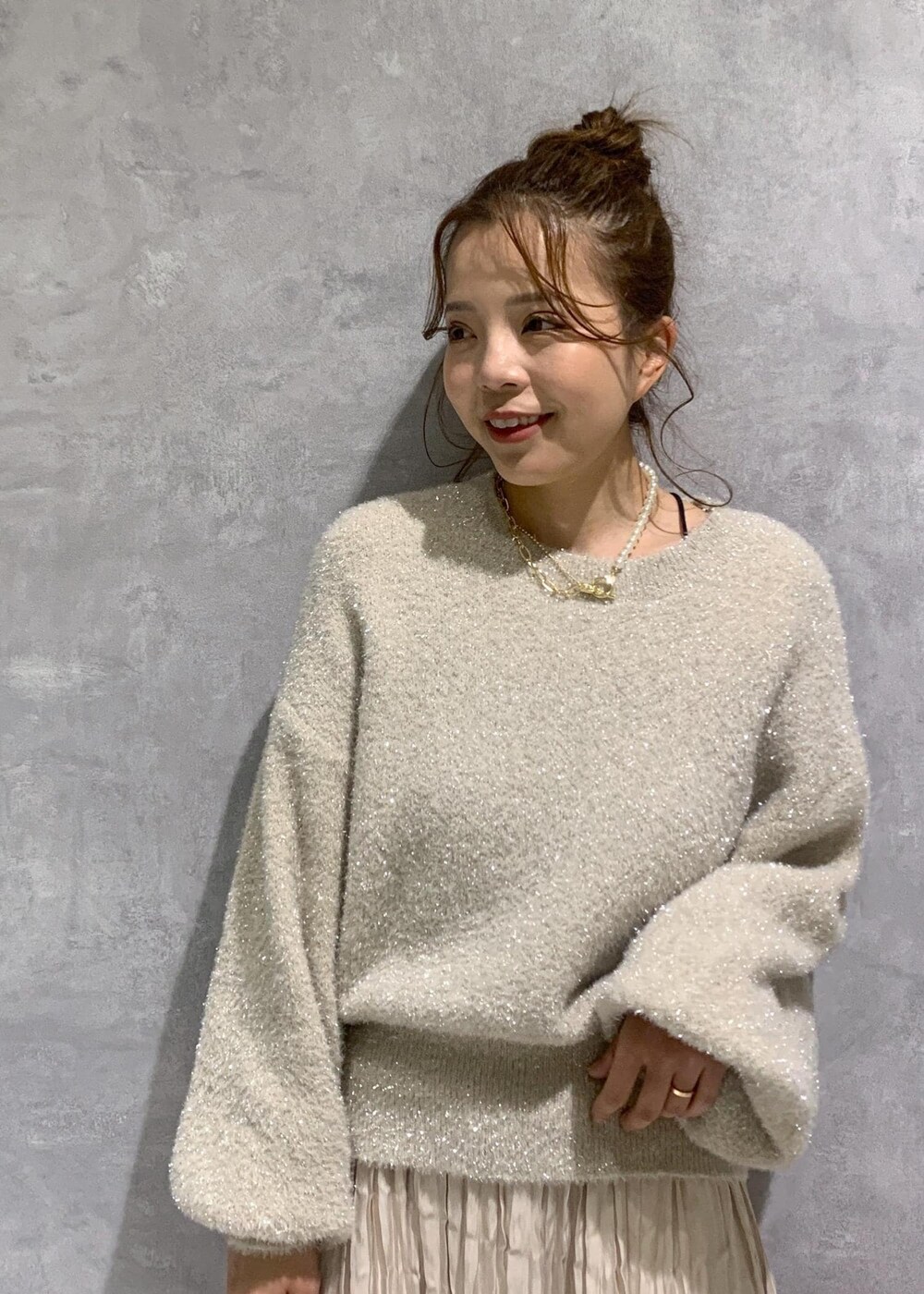 ピンク系のショルダーバッグ、ホワイト系のブーツ、ベージュ系のスカートを着用したレディースの冬コーディネートの7枚目の写真