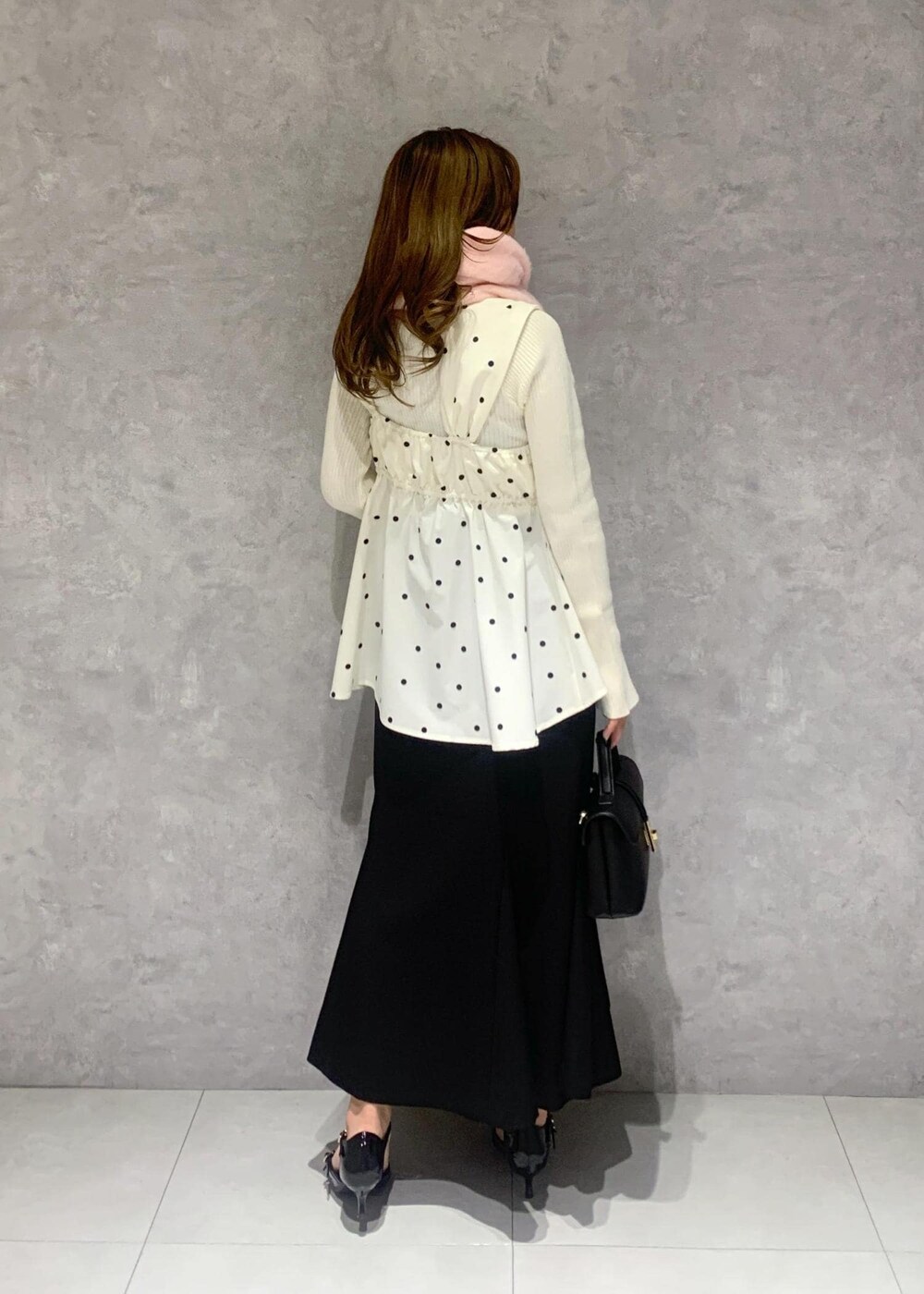 ブラック系のショルダーバッグ、ホワイト系のニット/セーター、ブラック系のスカートを着用したレディースの冬コーディネートの6枚目の写真