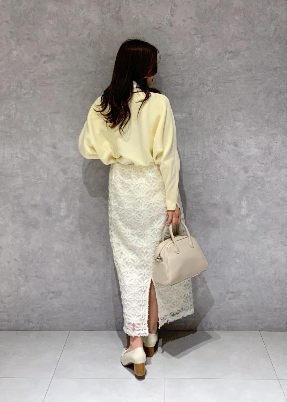 ホワイト系のスカート、ベージュ系のニット/セーター、ホワイト系のローファーを着用したレディースの冬コーディネートの5枚目の写真