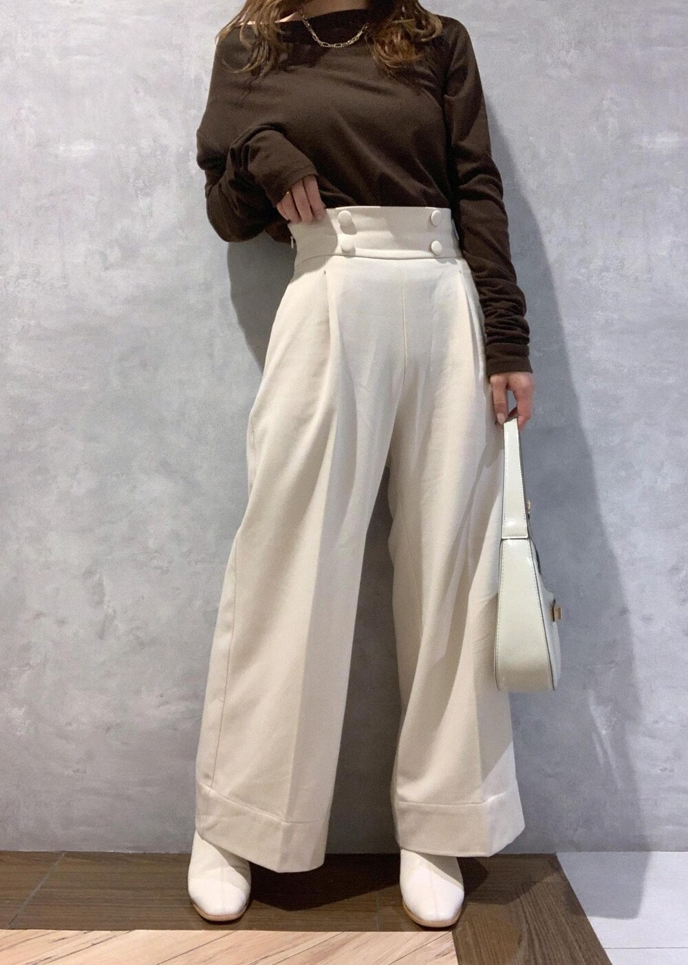 ホワイト系のブーツ、ホワイト系のハンドバッグ、ベージュ系のその他パンツを着用したレディースの秋コーディネートの8枚目の写真