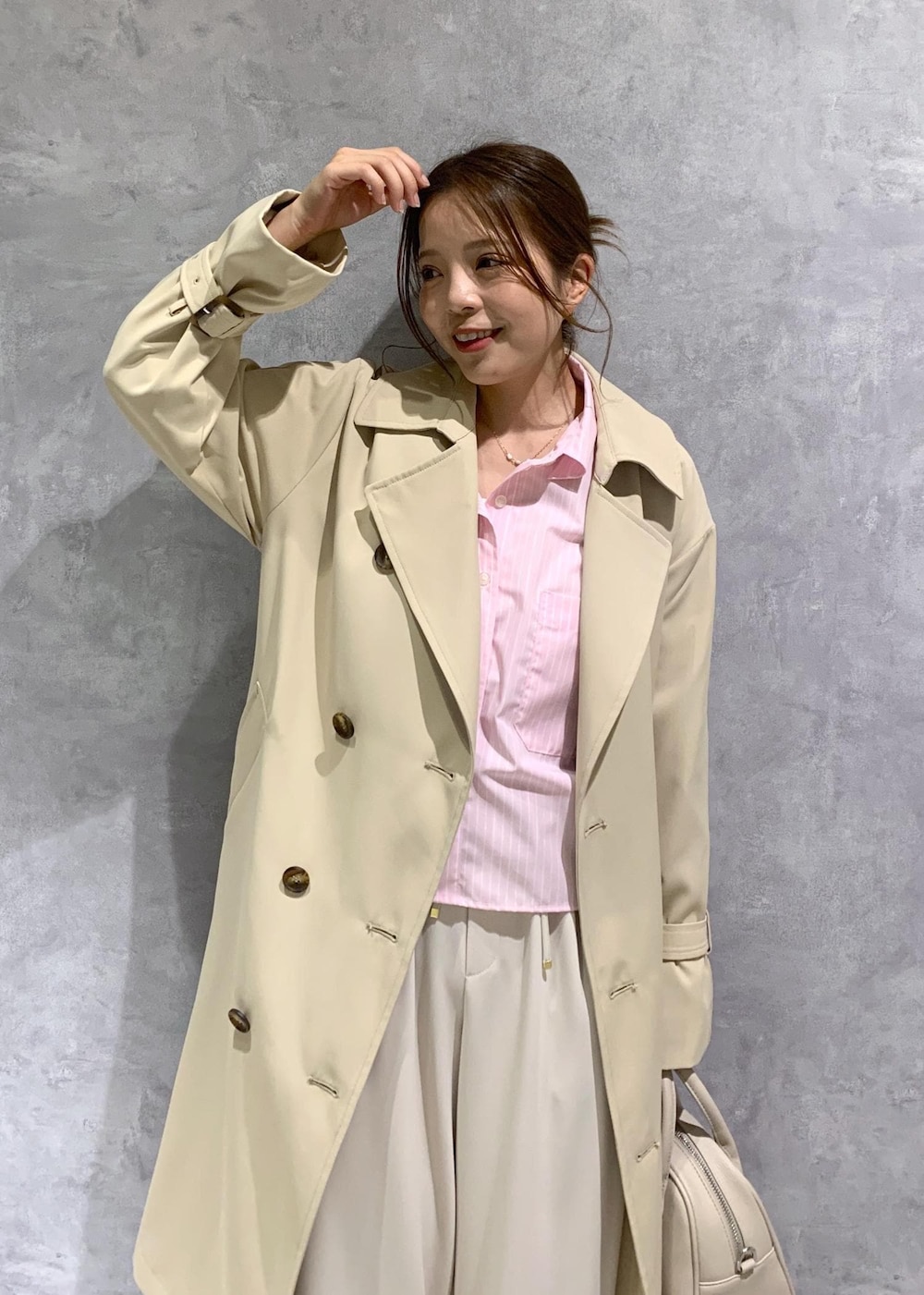 ベージュ系のボストンバッグ、ピンク系のシャツ/ブラウス、ベージュ系のトレンチコートを着用したレディースの春コーディネートの6枚目の写真