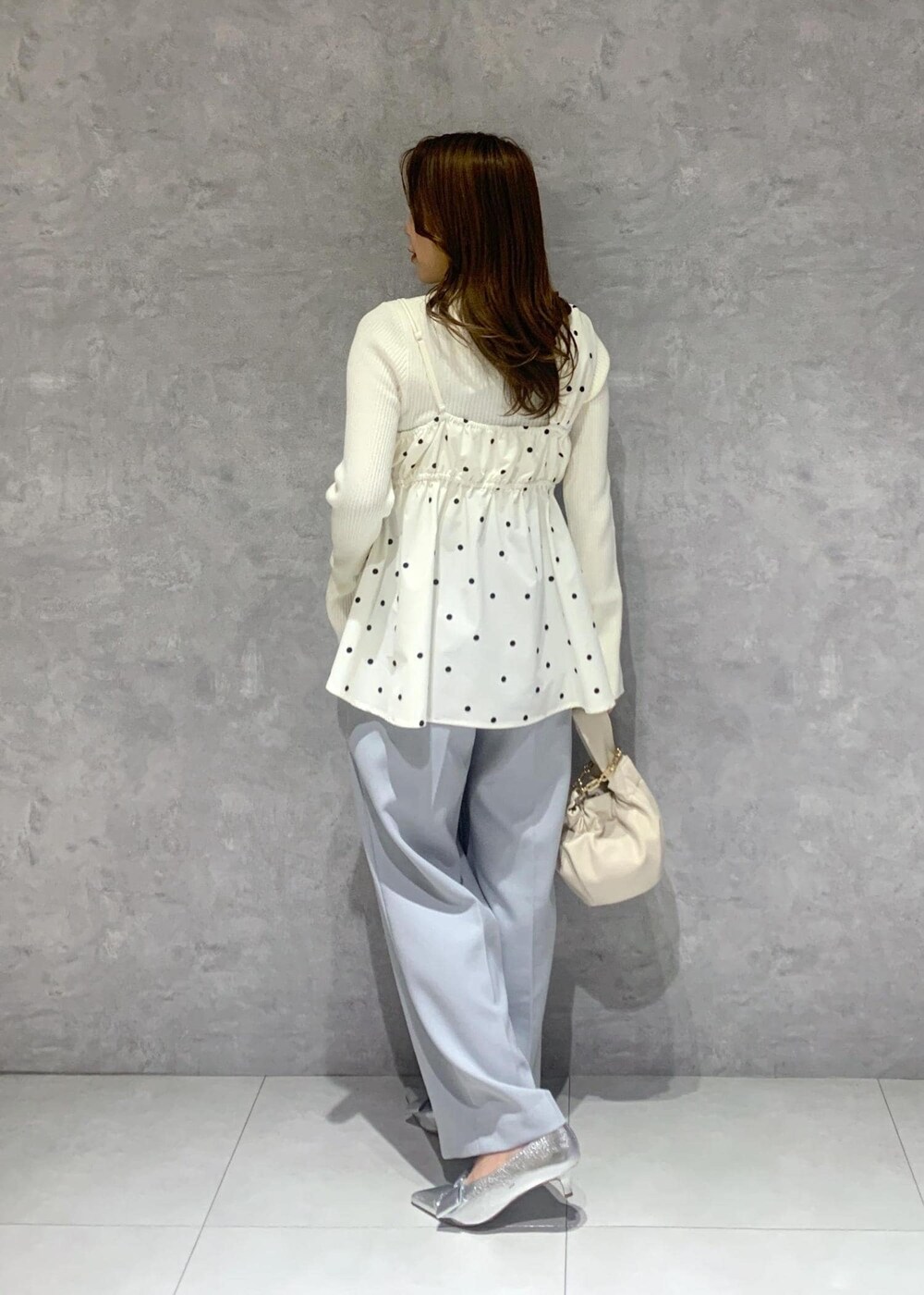 シルバー系のパンプス、ホワイト系のハンドバッグ、ホワイト系のニット/セーターを着用したレディースの冬コーディネートの5枚目の写真
