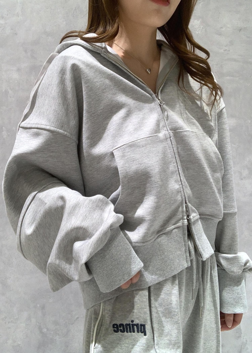 グレー系のその他パンツ、グレー系のパーカー、ホワイト系のショルダーバッグを着用したレディースの冬コーディネートの10枚目の写真