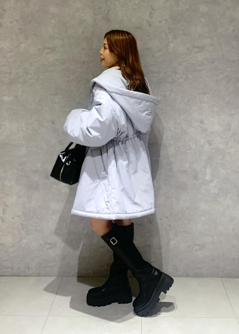 ブラック系のブーツ、ブラック系のスカート、ブルー系のその他アウターを着用したレディースの秋コーディネートの3枚目の写真