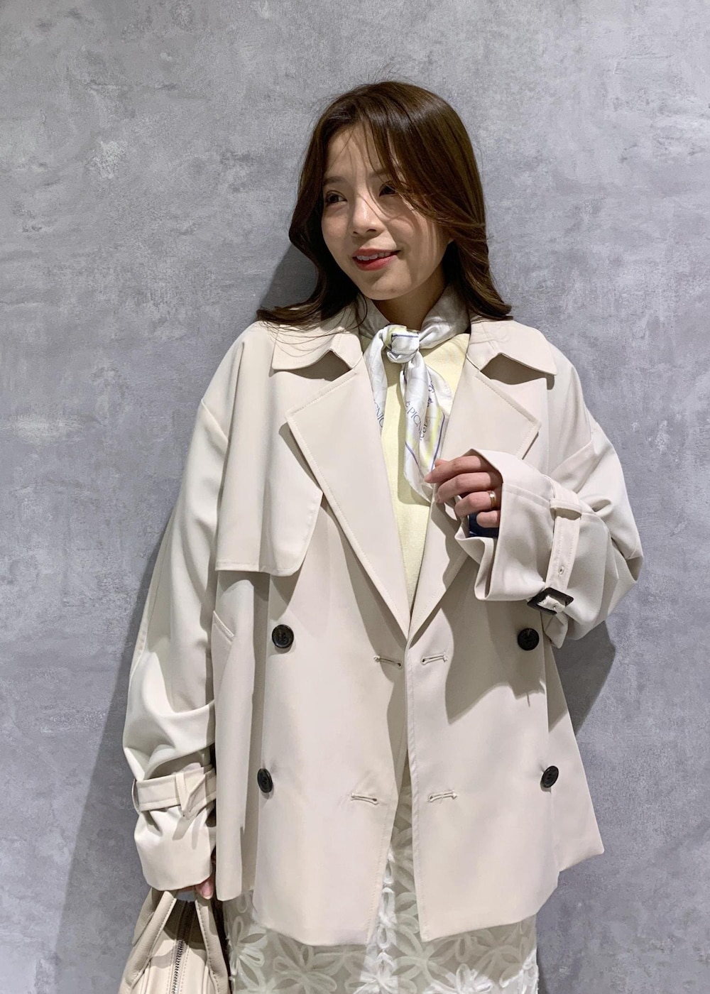 ホワイト系のスカート、ベージュ系のトレンチコート、ベージュ系のニット/セーターを着用したレディースの冬コーディネートの8枚目の写真