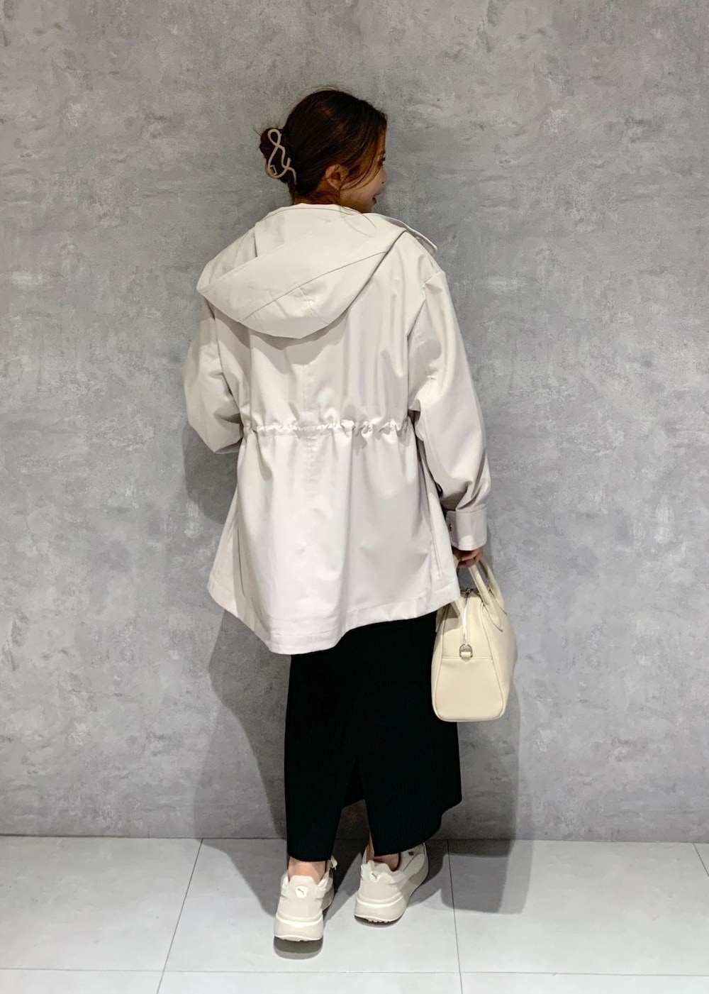 ブラック系のスカート、ベージュ系のボストンバッグ、グレー系のマウンテンパーカーを着用したレディースの春コーディネートの5枚目の写真