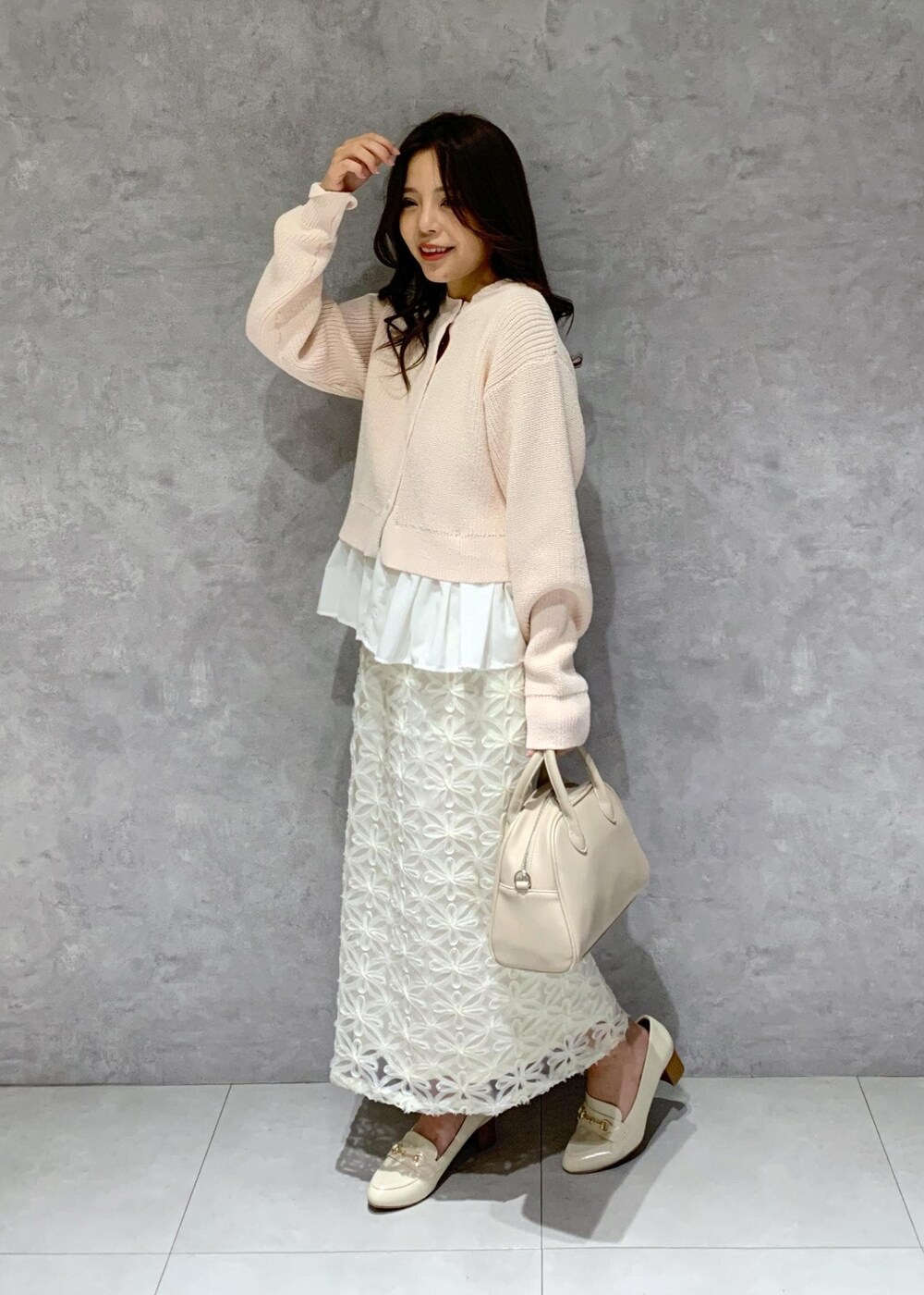 ホワイト系のローファー、ベージュ系のボストンバッグ、ピンク系のカーディガン/ボレロを着用したレディースの冬コーディネートの3枚目の写真