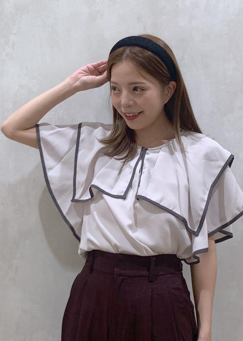 ブラウン系のスラックス、ブラック系のハンドバッグ、ブラック系のサンダルを着用したレディースの夏コーディネートの5枚目の写真