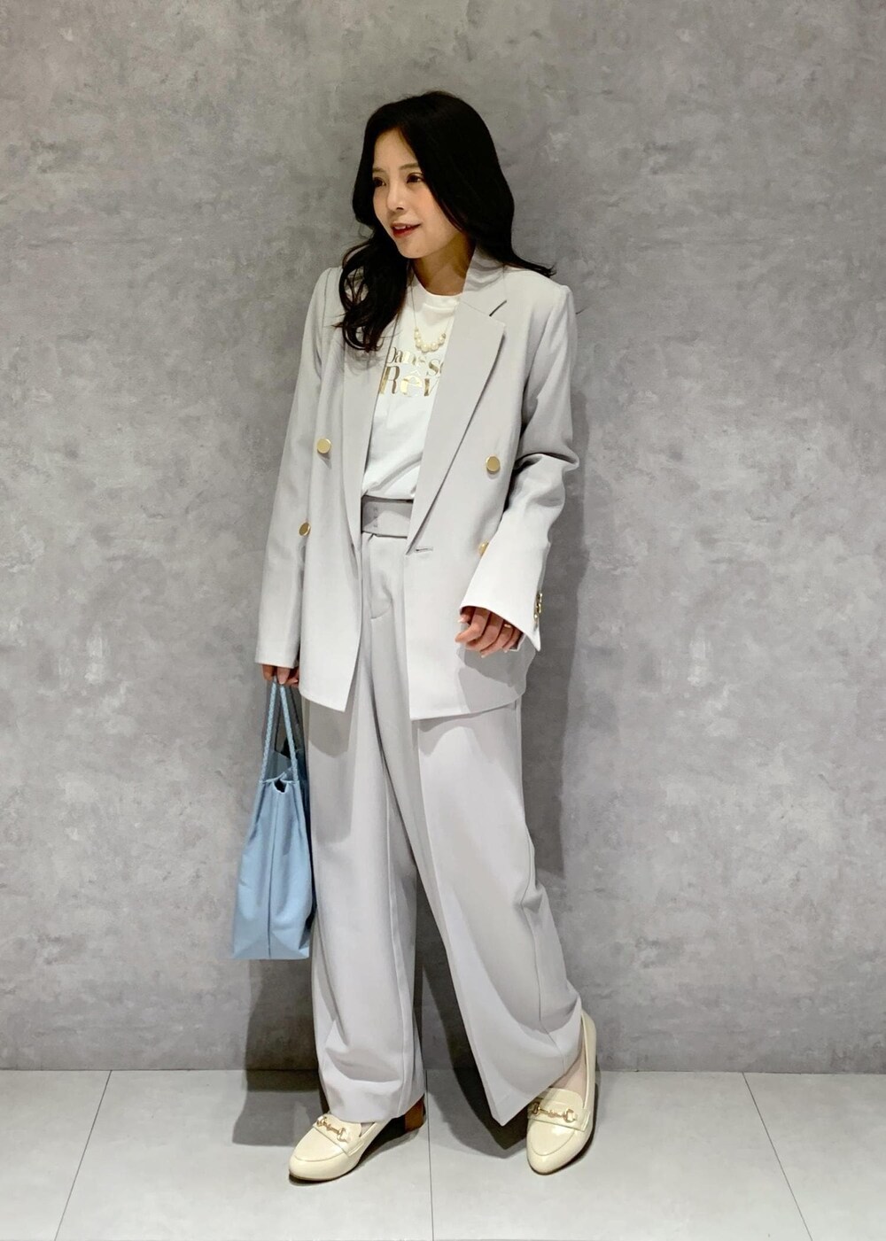 ブルー系のトートバッグ、ホワイト系のTシャツ/カットソー、ホワイト系のローファーを着用したレディースの冬コーディネートの3枚目の写真