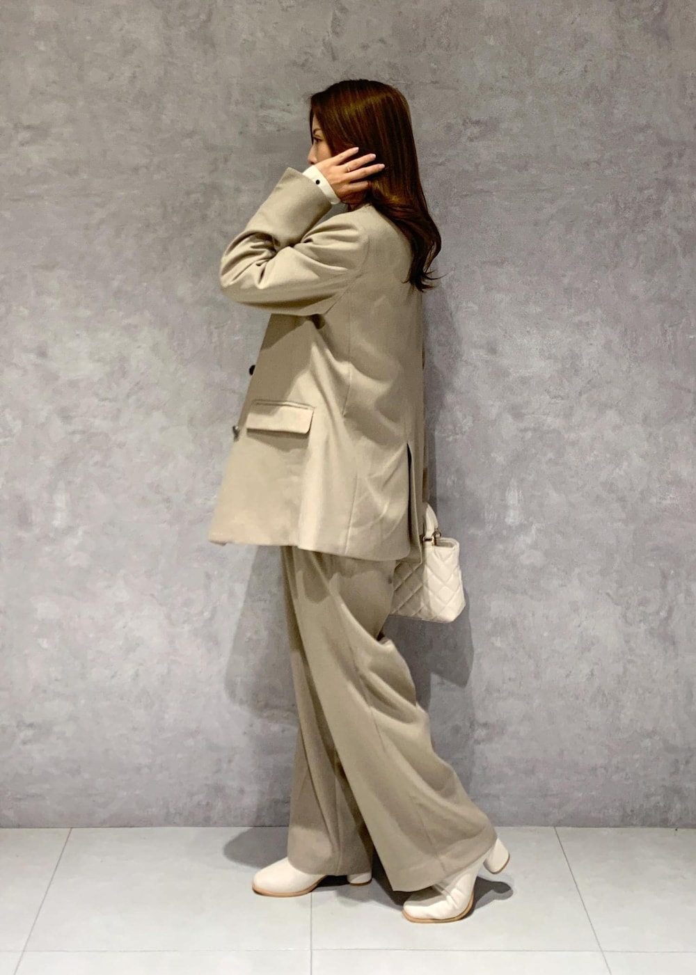 ホワイト系のブーツ、ベージュ系のシャツ/ブラウス、ベージュ系のスラックスを着用したレディースの冬コーディネートの4枚目の写真