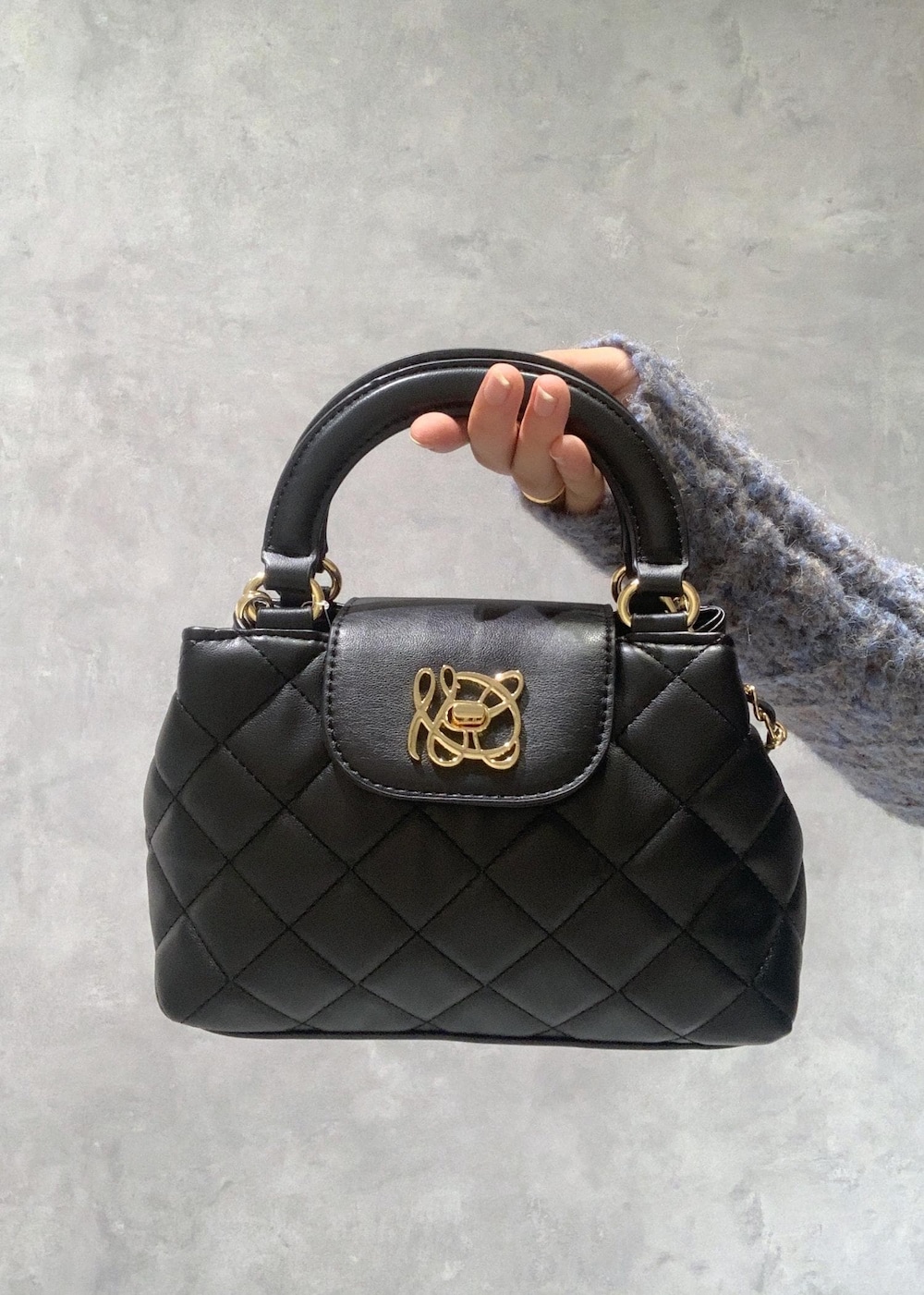 ホワイト系のカーディガン/ボレロ、ブラック系のパンプス、ホワイト系のスカートを着用したレディースの冬コーディネートの9枚目の写真